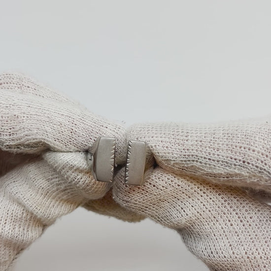Showing single silver-colored titanium signet ring, 15x15 mm wide surface witch has been cut through the middle, from all angles.